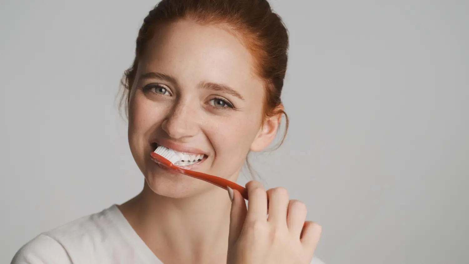 Mujer cepillándose los dientes correctamente como parte del tratamiento para encías inflamadas
